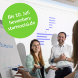 Die Grafik zeigt ein Foto von startsocial mit Menschen im Gespräch vor einem Flipchart.