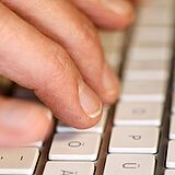 Foto zeigt eine schreibende Hand an der Tastatur